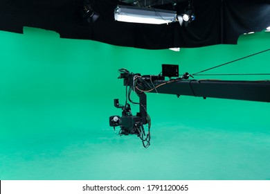 Broadcast Television Studio Camera Jib In Greenscreen Studio Room With LED Lights On The Ceiling.