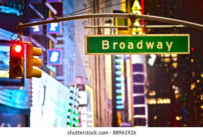Broadway sign and red stop light in New York City at night