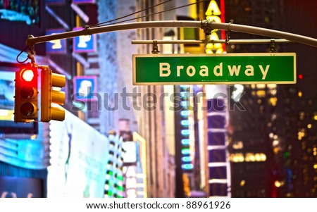 Broadway sign and red stop light in New York City at night