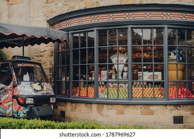 Broadway, UK - July 07, 2020: Fresh fruits and organic goods in a window of a Broadway Deli in Broadway, a large historic village within the Cotswolds in the county of Worcestershire, England.