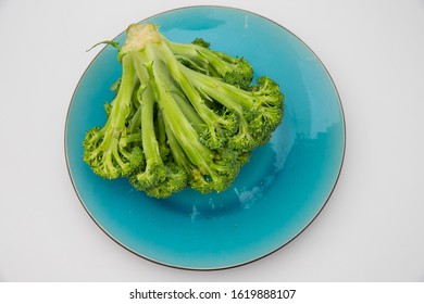 Broccoli Crown Close Up On Bright Plate And White Background