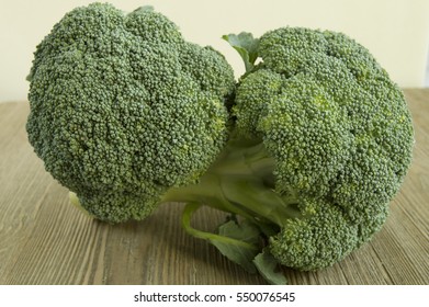 Broccoli Crowns Resting On Wooden Table