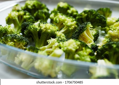 Broccoli In The Glass Baking Dish Prepared For Baking. On The White Table. Diet Recipe. Close Up.