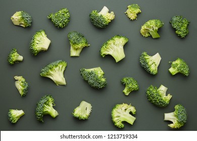 Broccoli pattern isolated on a dark green background. Various multiple parts of broccoli flower. Top view.