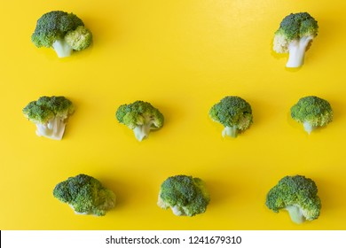 Broccoli pieces are arranged in rows on a yellow background with place  for text.