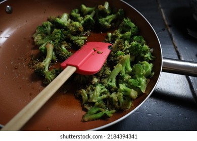 Broccoli In A Skillet With A Red Spatula