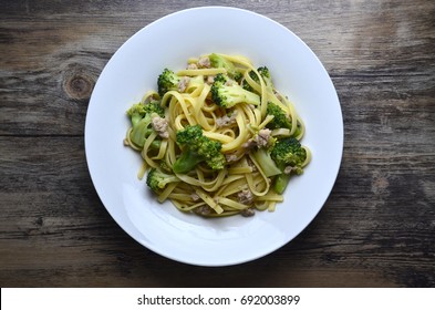 Broccoli Spaghetti In White Plate On Wooden Table With Top Down View