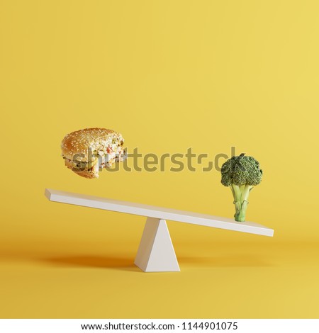 broccoli vegetable tipping seesaw with floating berger on opposite end on yellow background. food idea minimal.