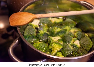 Brocolli In A Pot In The Kitchen With A Wooden Cooking Spoon View From Above