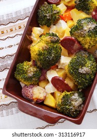 Brocolli And Potato Casserole In A Baking Dish On The Table. Shot Over Table Cloth From Above.