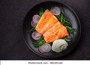 Broiled Salmon With Radish And Spinach, Served On Black Plate. View From Above, Top Studio Shot