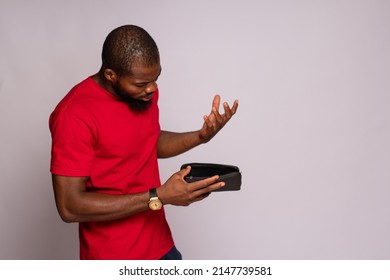 Broke African Man Holding An Empty Wallet