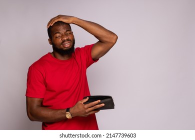 Broke African Man Holding An Empty Wallet