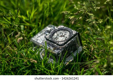 broken action camera in a protective case in the grass