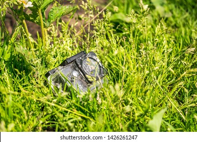 broken action camera in a protective case in the grass
