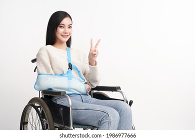 Broken Arm Beautiful Young Asian With Happy Smiling Woman In A Wheelchair On White Background, Healthcare Concept, Accident, Insurance, Life Insurance, Wellness, Hospital.