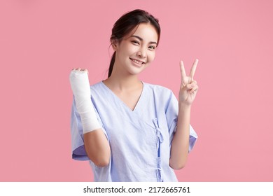 Broken Arm,  Beautiful Young Asian With Happy Smiling Woman On Pink Background, Healthcare Concept, Accident, Insurance, Life Insurance, Wellness, Hospital.