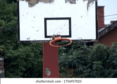 Broken Basketball Hoop Hanging On Backboard In Old School Yard