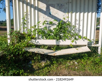 Broken Bench At The Old Bus Stop. Abandoned. Stop Overgrown With Plants. Abandoned Infrastructure. Broken Seat
