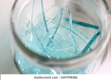 Broken Blue Glass In A Glass Jar.