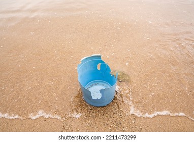Broken Blue Plastic Bucket On A Sandy Beach