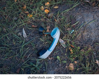 A Broken Blue Telephone Receiver Lies On The Grass. Old Vintage Telephone. Sunny Autumn Day.