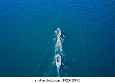 Broken boat in tow in motion on the water, aerial view of the boat