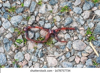 Broken Brown Tortoise Shell Glasses Frame On Rocky Gravel Ground.