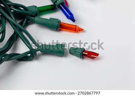 Broken bulb in Christmas string lights. Holiday lighting repair, safety and decoration concept.