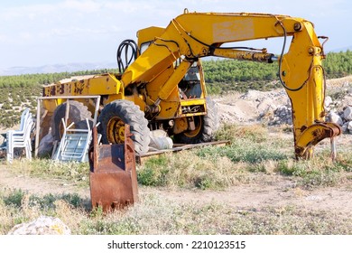 Broken Bulldozer City Construction. Broken Machinery Unfinished Construction. A Broken Yellow Tractor Being Parked In The Yard.