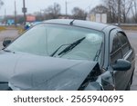 Broken bumper and hood of a car as a result of a collision with a pole. The car crashed into a lamp post. Road accident. Close-up of a passenger car.