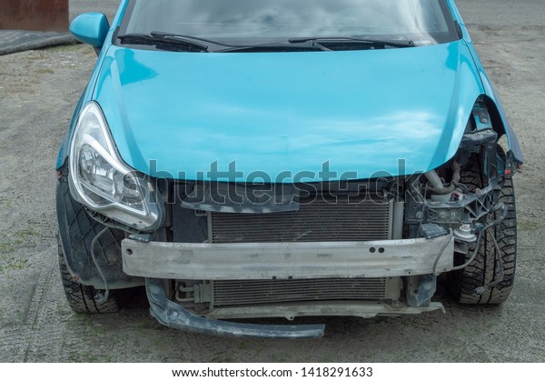 broken in a car accident in front of a blue car. \
Front view