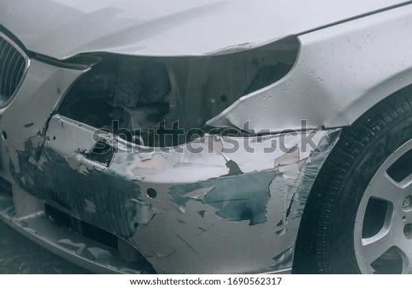 Broken car.\
Accident on the road, damaged car. Broken front of a car after an\
accident: bumper, headlight,\
hood.