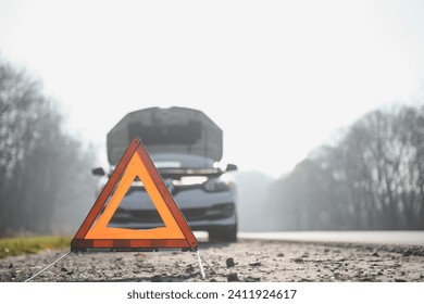 Broken car concept, breakdown triangle on road.