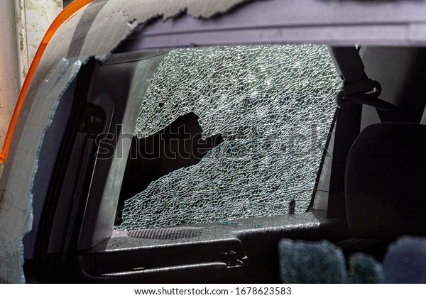 Broken\
car glass in an accident. Damaged automotive glass background\
pattern. Broken car as a result of a road\
accident