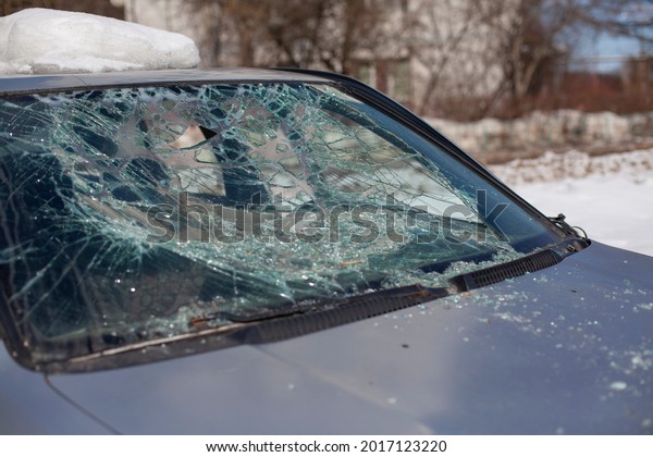 Broken car glass. The windshield\
cracked. Damaged transport. The car is in the parking lot\
broken.