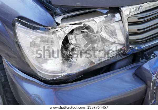 broken car headlight closeup, big cars accident on\
the road in the city	
