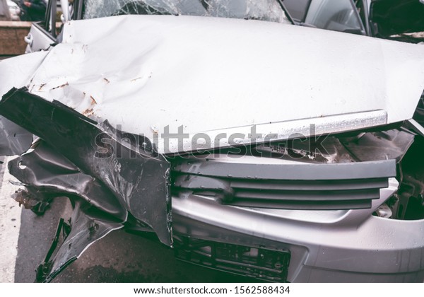  Broken car on the\
road. The body of the car is damaged as a result of an accident.\
High speed head on a car traffic accident. Dents on the car body\
after a collision on the