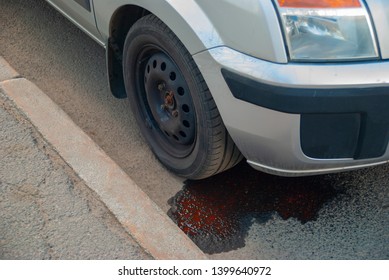 Broken Car On The Roadside. Oil Leak From The Engine On The Asphalt.