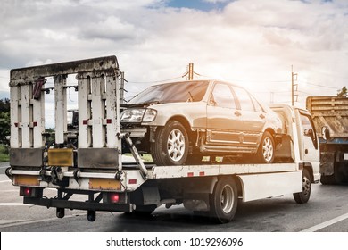 Broken car on tow truck after traffic accident, on the road service