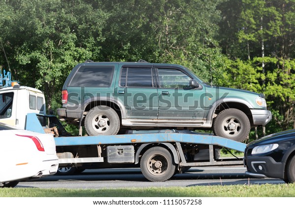 Broken car on tow truck after traffic accident,\
on the road service
