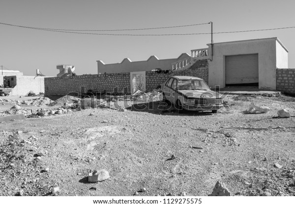 Broken car in the village of Tunisia far in\
Pre-Sahara desert