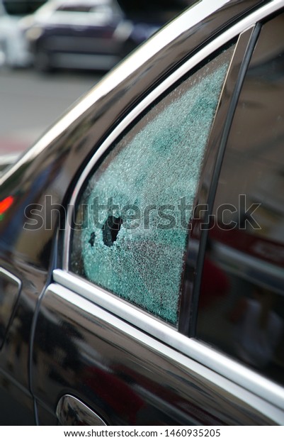 Broken car window on\
the street         