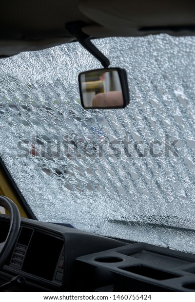 broken car window,\
windshield after car accident, rockfall. web of splits on an old\
windscreen. Accident\
concept
