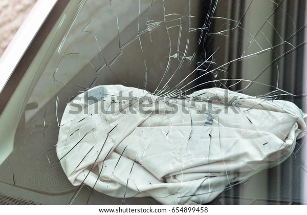 A broken car\
windscreen and an air bag
