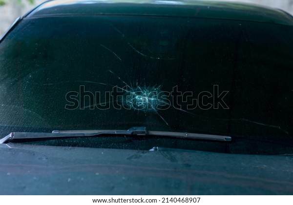 Broken car windshield .Crash windshield glass \
the broken and damaged car. Tempered glass  shattered in an\
accident. Broken\
Windshield