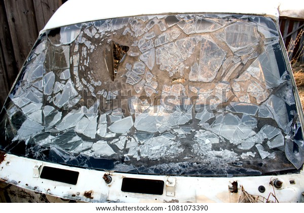 The\
broken car windshield. Dirty splinters of\
glass.