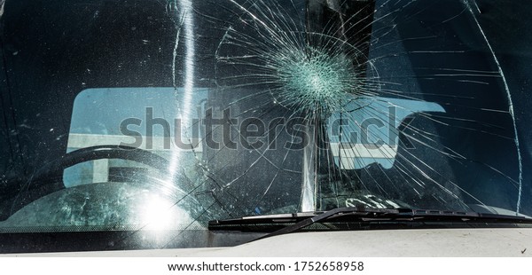 Broken car windshield. Web of radial cracks, crack
on triple windshield. Broken windshield car, damaged glass with
traces of an oncoming stone on road or trace of downed pedestrian
or animal on road