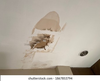 Broken ceiling problem in house because rain water damage in raining season. Ceiling panels damaged huge hole in roof from rainwater leakage.