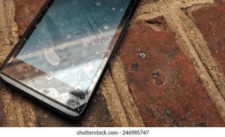 Broken Cell Phone On Break Ground Close Up. Selective Focus Image